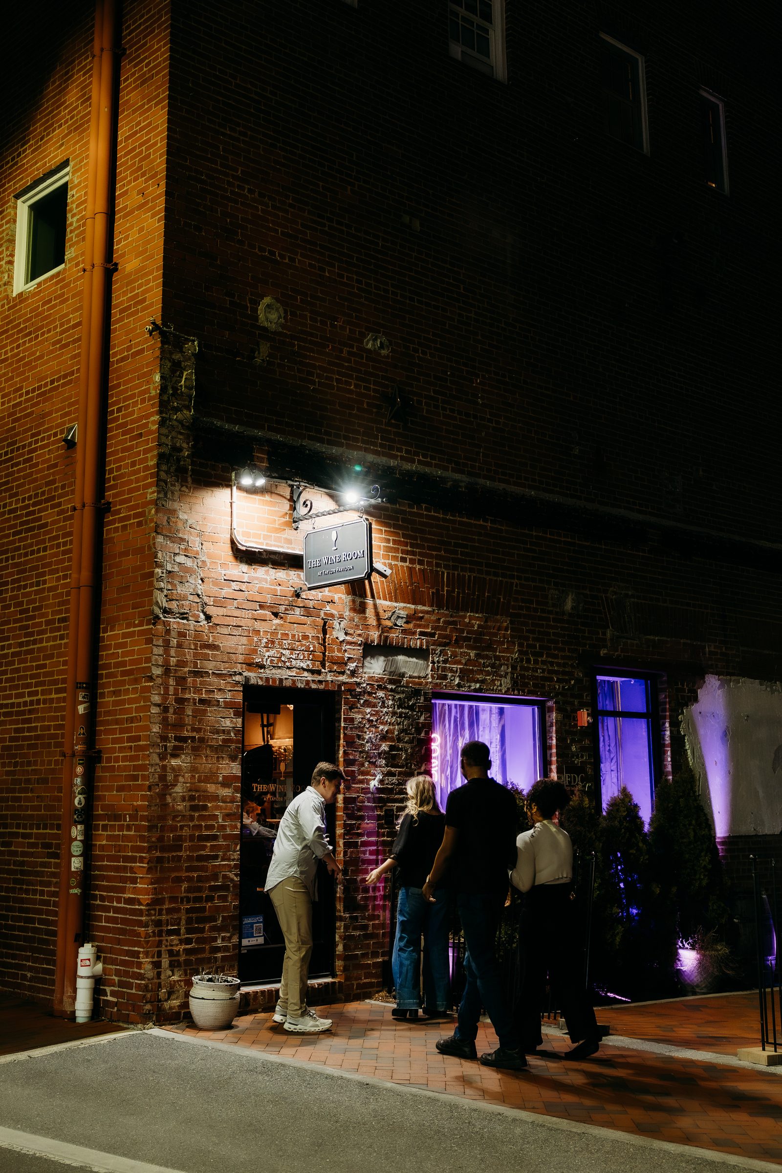The brick entrance to The Wine Room on Indian Alley at night